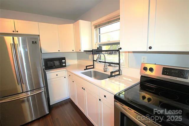 a kitchen with a stove a refrigerator and a window