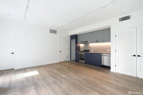 a kitchen with granite countertop a refrigerator and a sink