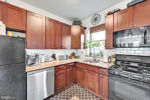 a kitchen with stainless steel appliances granite countertop a sink stove refrigerator and cabinets