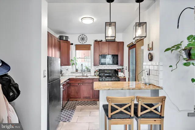 a kitchen with stainless steel appliances granite countertop a sink a stove and a wooden floors