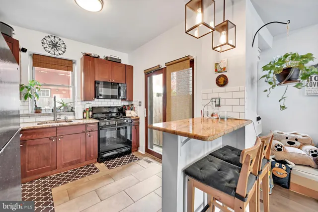 a kitchen with stainless steel appliances kitchen island granite countertop a stove a sink and a microwave