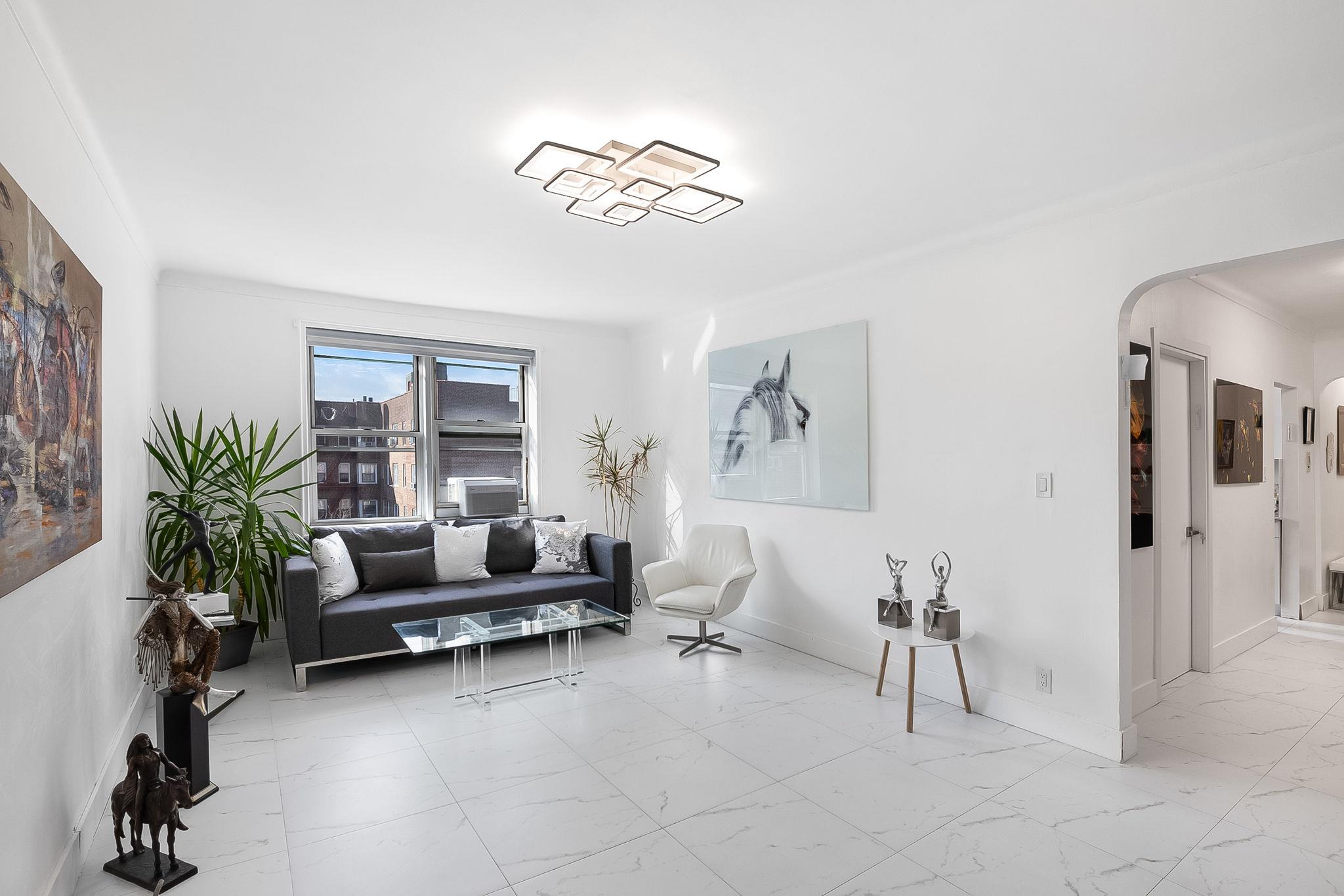 99-31 64th Avenue, Unit E10 Queens, NY 11374 - Photo 1 of 14 a living room with furniture and a large window