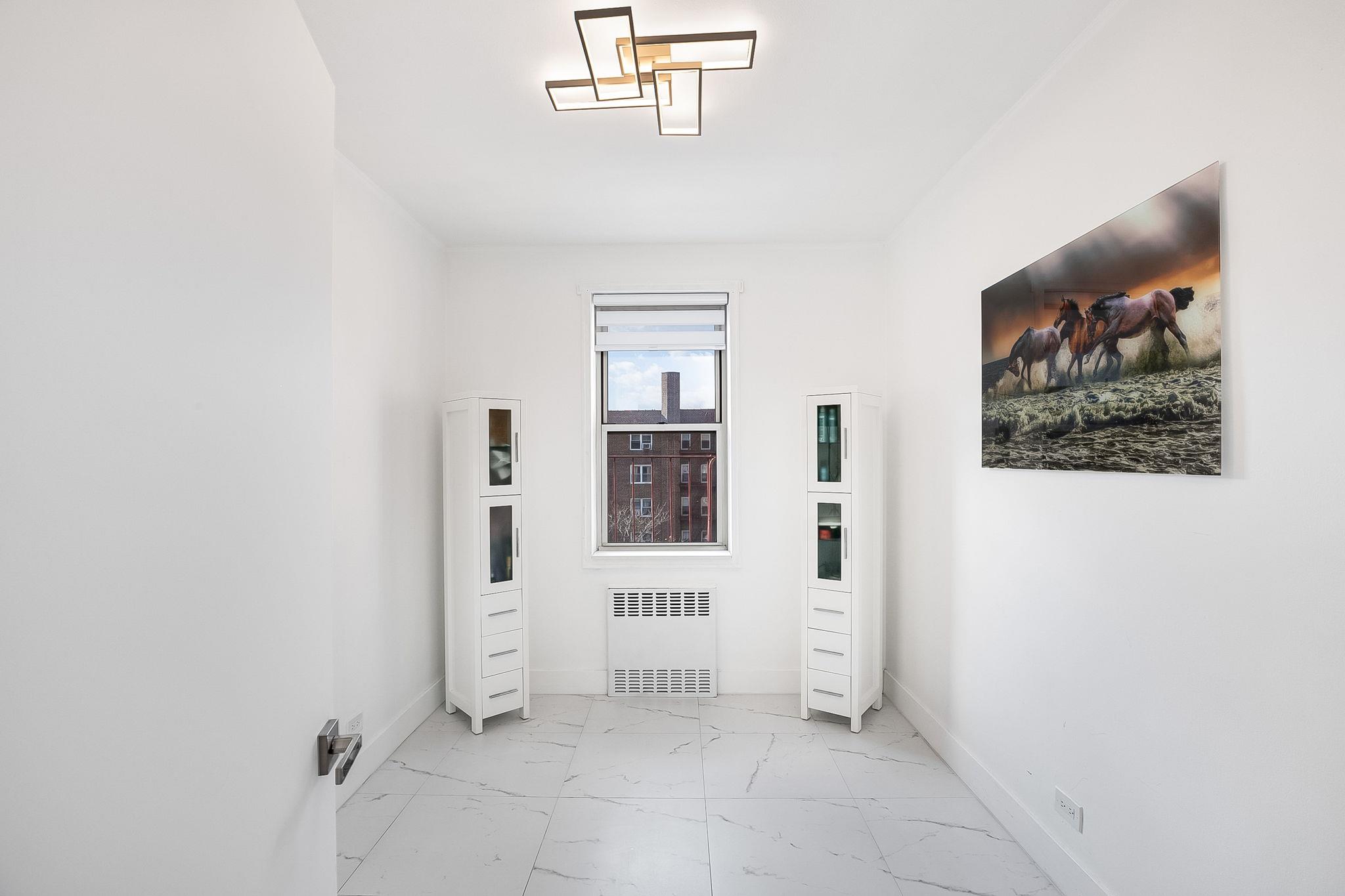 99-31 64th Avenue, Unit E10 Queens, NY 11374 - Photo 9 of 14 an empty room with windows and closet