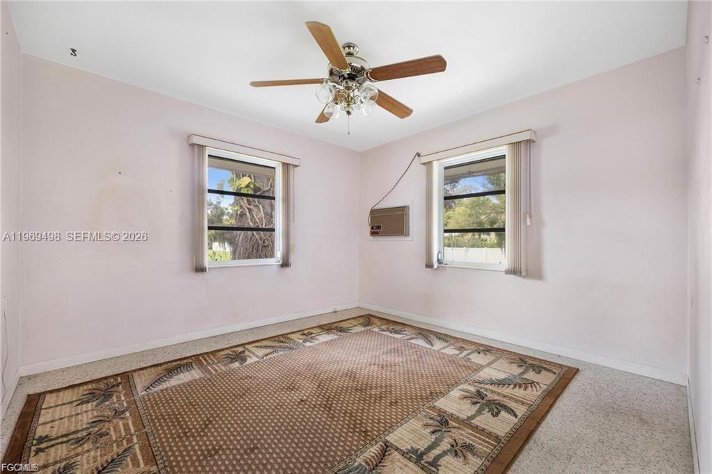 2030 Fort Denaud Road LaBelle, FL 33935 - Photo 18 of 25 an empty room with wooden floor ceiling fan and windows