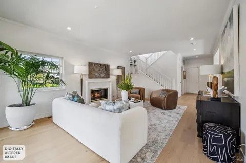a living room with fireplace furniture and a potted plant