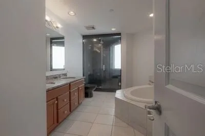 a bathroom with a granite countertop sink a toilet a mirror and shower