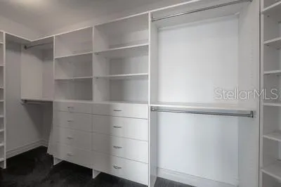 a view of walk in closet with empty racks