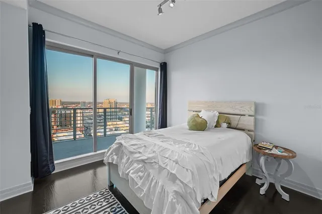 a large bed sitting in a bedroom next to a window