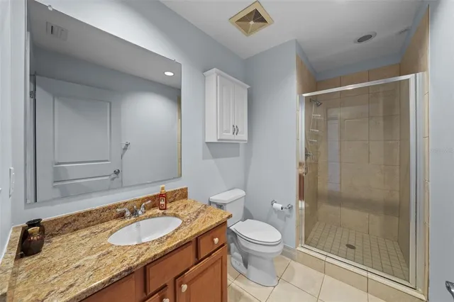 a bathroom with a granite countertop sink toilet mirror and shower