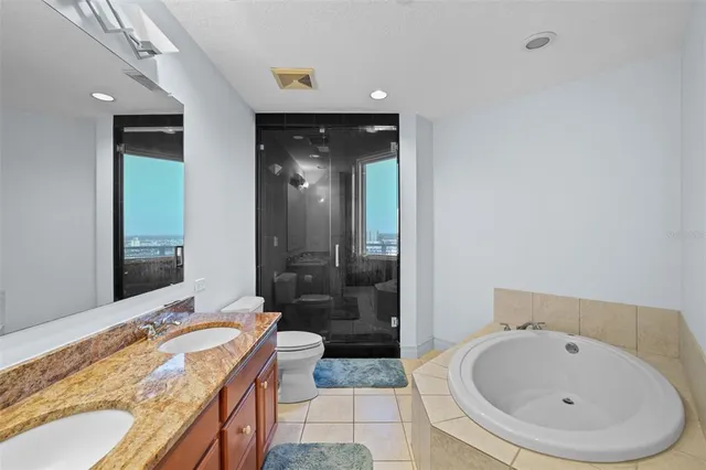 a bathroom with a granite countertop sink a toilet and shower