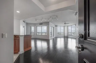 an empty room with wooden floor and windows