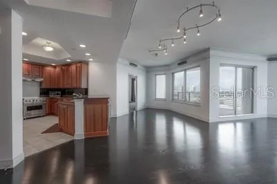 a view of a kitchen with refrigerator and wooden floor