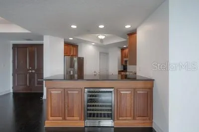 a kitchen with kitchen island granite countertop wooden cabinets a refrigerator and a sink