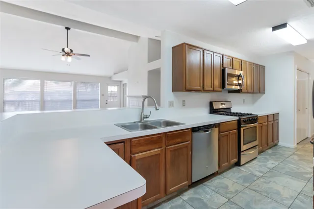 a kitchen with stainless steel appliances granite countertop a refrigerator and a stove top oven