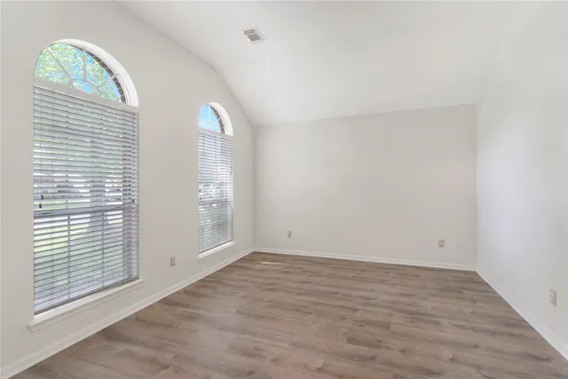 a view of an empty room with a fireplace and a window