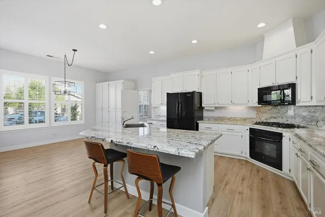 a kitchen with a stove a sink a microwave a refrigerator and cabinets