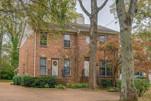 front view of a brick house with a small yard