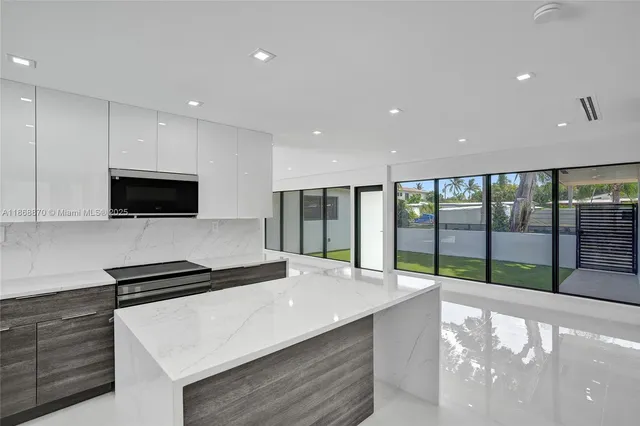 a large kitchen with stainless steel appliances a large counter top and a stove