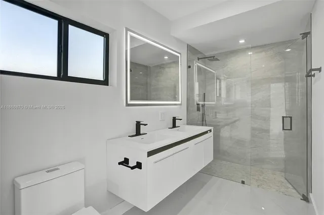 a bathroom with a sink shower and a mirror