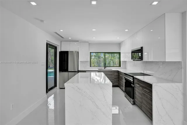 a kitchen with a sink a counter top space stainless steel appliances and cabinets