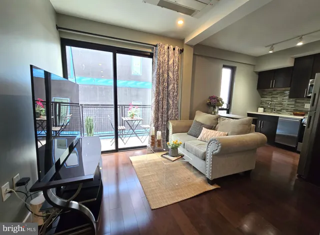 a living room with furniture floor to ceiling window and wooden floor
