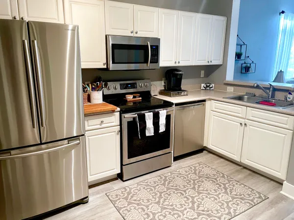 a kitchen with stainless steel appliances white cabinets sink and a stove