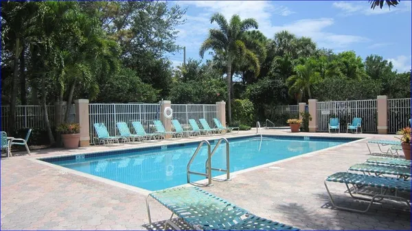 a view of a swimming pool with chairs in patio