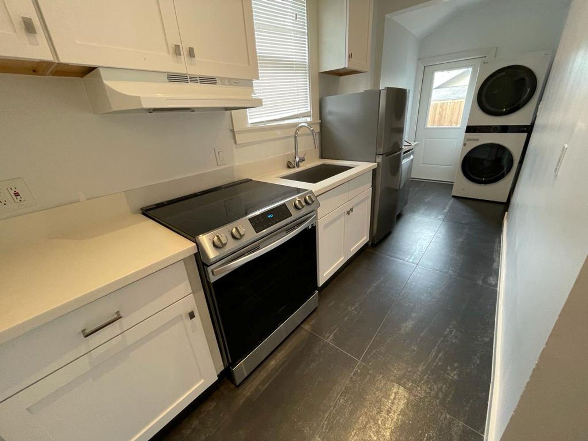 2118 Carter Street Houston, TX 77008 - Photo 4 of 8 Large galley style kitchen complete with quartz counters, stainless steel appliances and stackable washer dryer