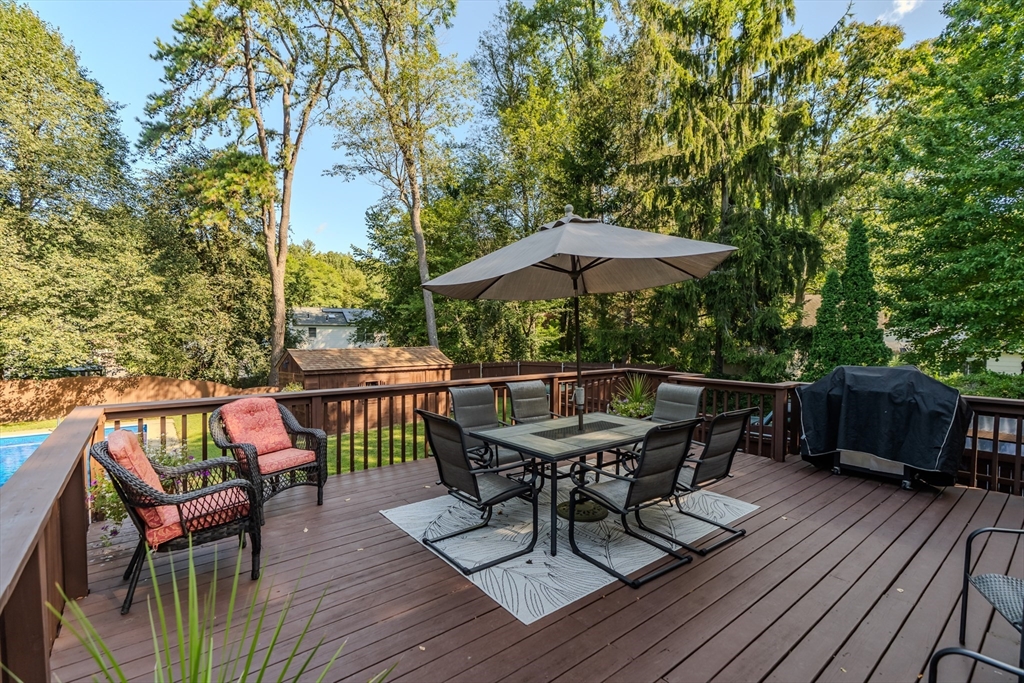 447 Ryan Road Northampton, MA 01062 - Photo 12 of 42 a view of deck with dinning table and chairs under an umbrella with wooden floor and fence