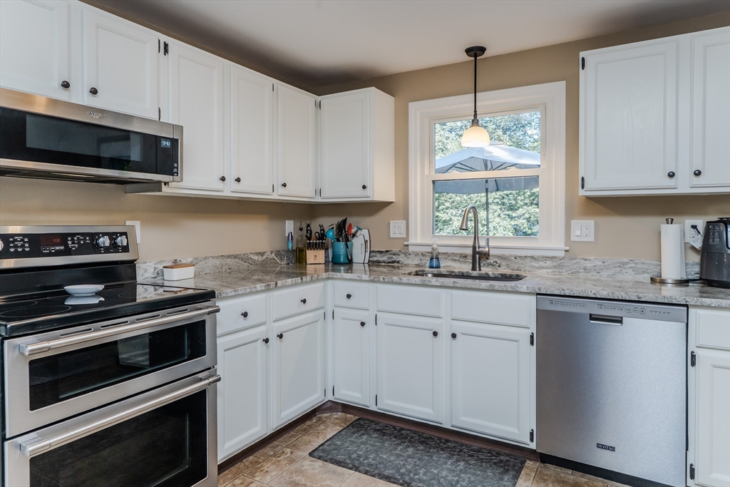 447 Ryan Road Northampton, MA 01062 - Photo 8 of 42 a kitchen with stainless steel appliances granite countertop white cabinets and window