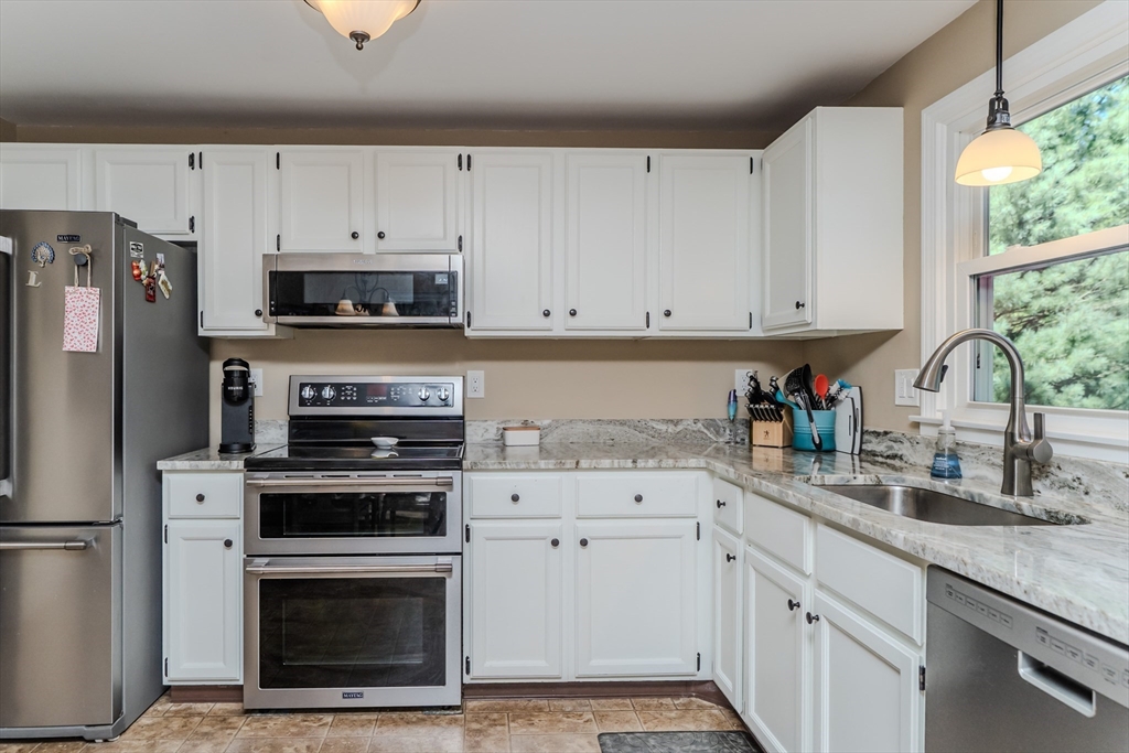 447 Ryan Road Northampton, MA 01062 - Photo 9 of 42 a kitchen with granite countertop white cabinets stainless steel appliances and a sink