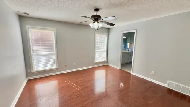 a spacious bathroom with a shower a sink and a mirror