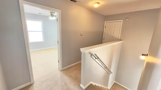 a view of a big room with a ceiling fan and a window
