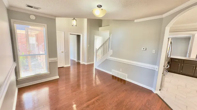 view of an empty room with wooden floor and a window
