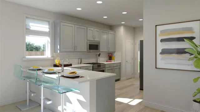 a kitchen with a sink a stove a refrigerator cabinets and a dining table