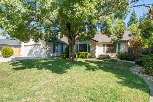 a view of a house with a yard and tree s