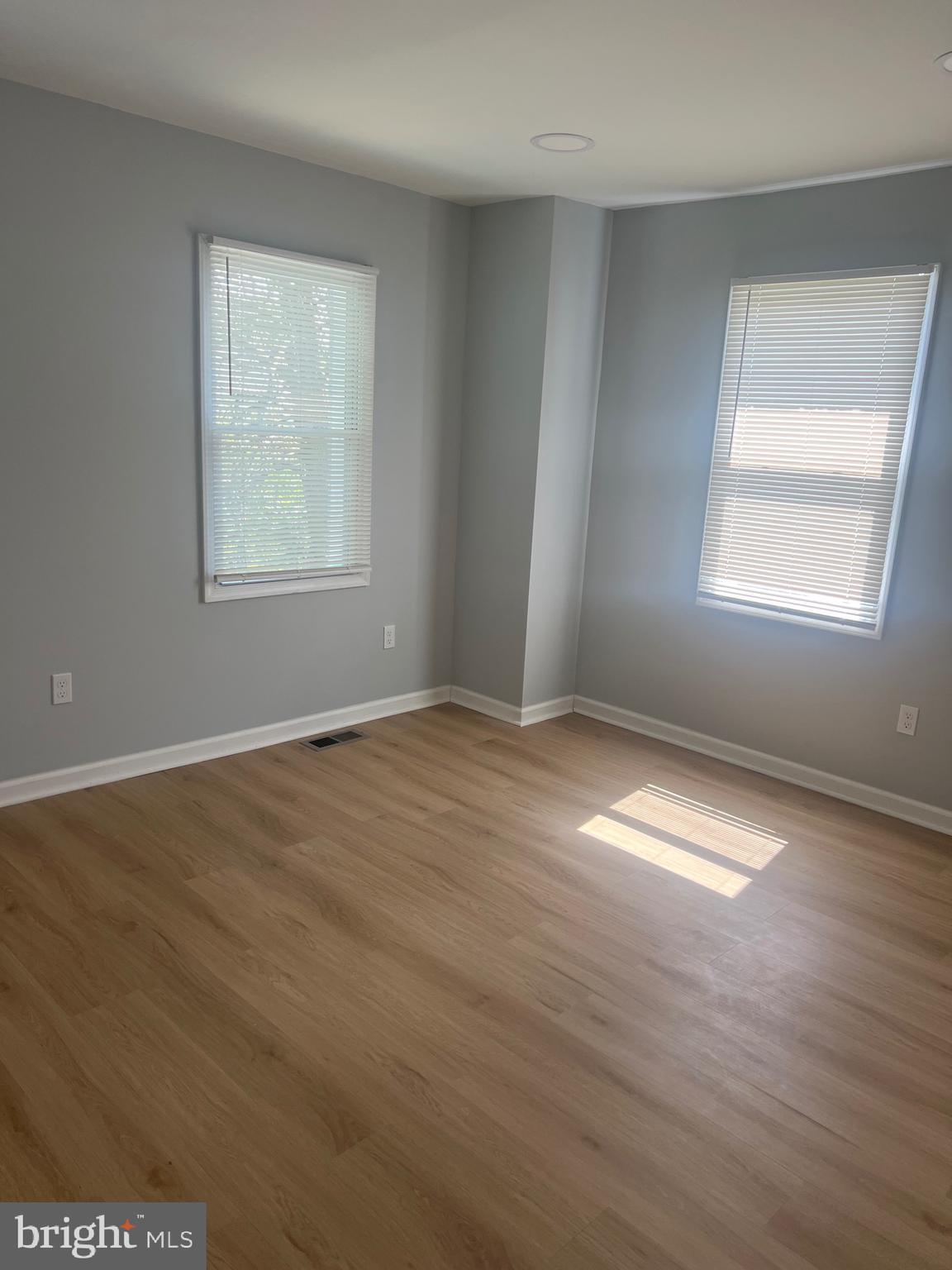 1208 Congress Street Southeast Washington, DC 20032 - Photo 3 of 12 an empty room with wooden floor and windows