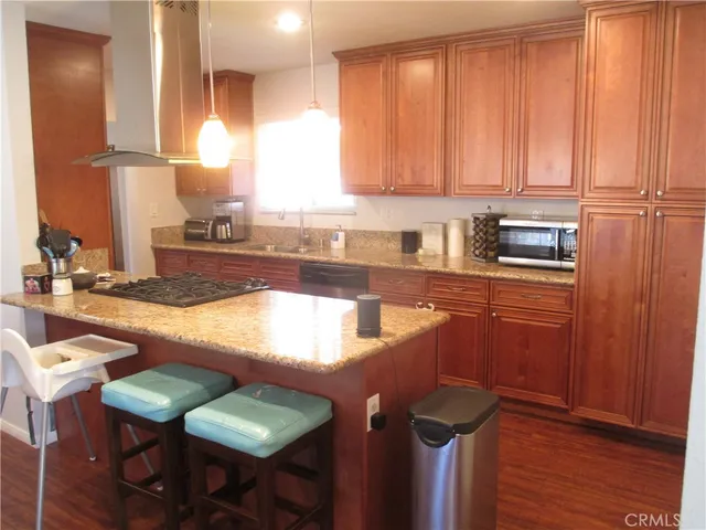 a kitchen with stainless steel appliances granite countertop wooden cabinets a sink and a stove