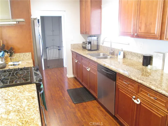 a large kitchen with granite countertop a sink and a window