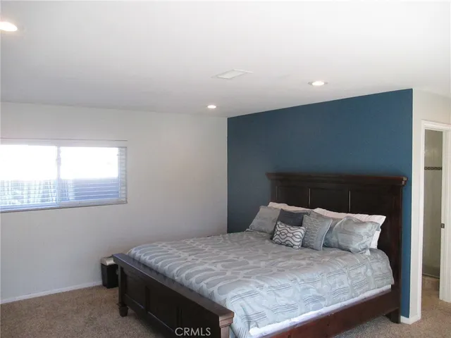 a bed sitting in a bedroom next to a window