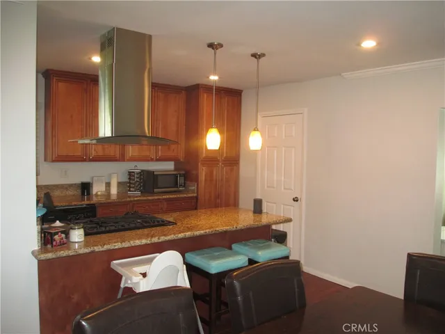 a kitchen with granite countertop a refrigerator a sink and a stove