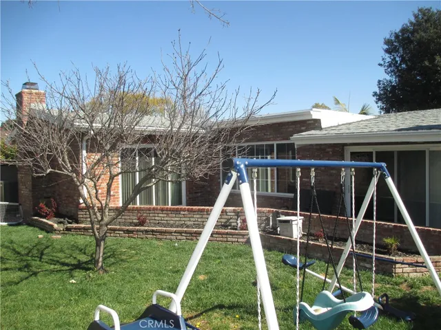 a view of a house with a wooden deck and a yard