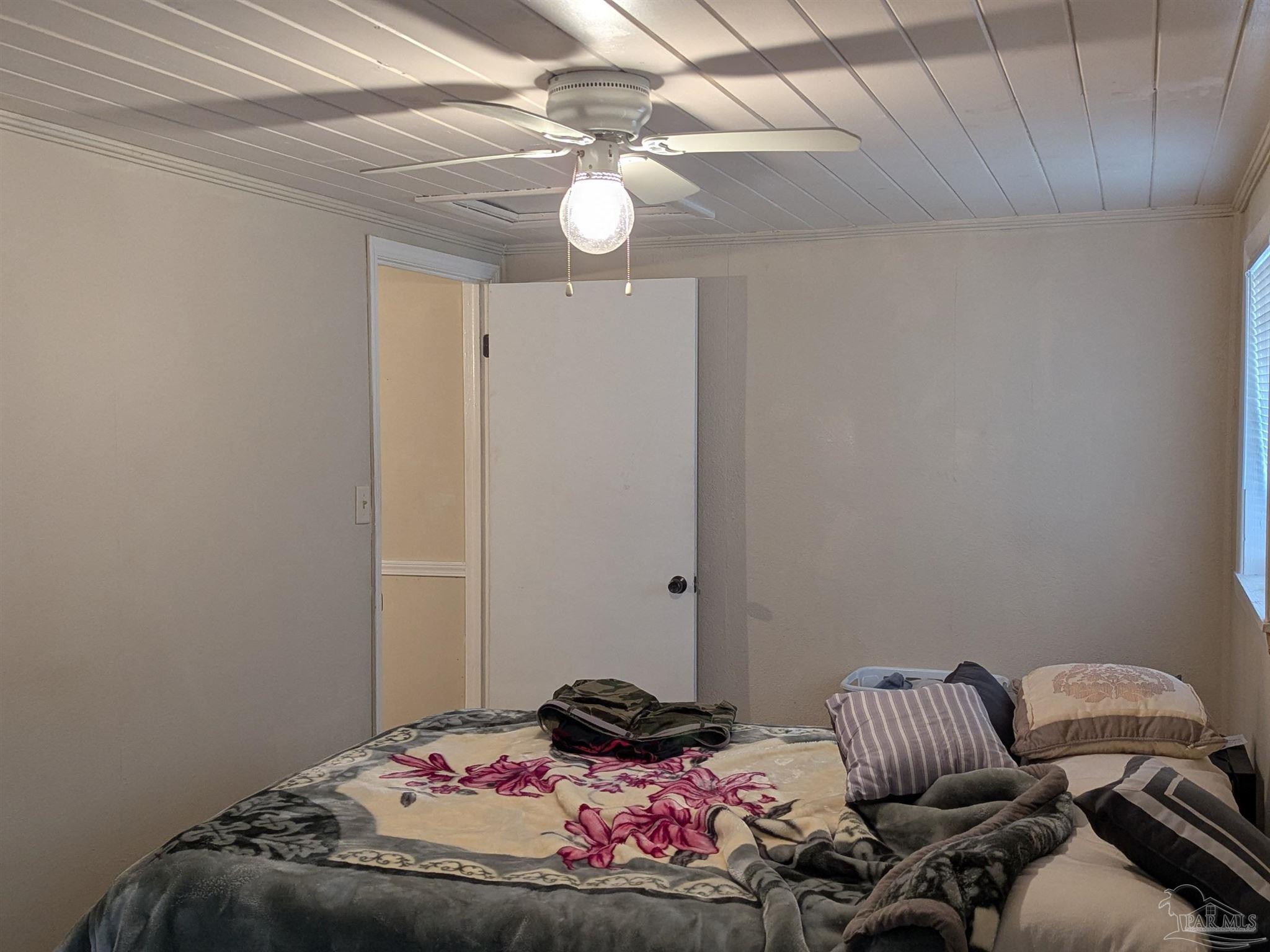 1036 Hawthorn Drive, Unit A/B Pensacola, FL 32507 - Photo 10 of 14 a bedroom with a bed and a chandelier