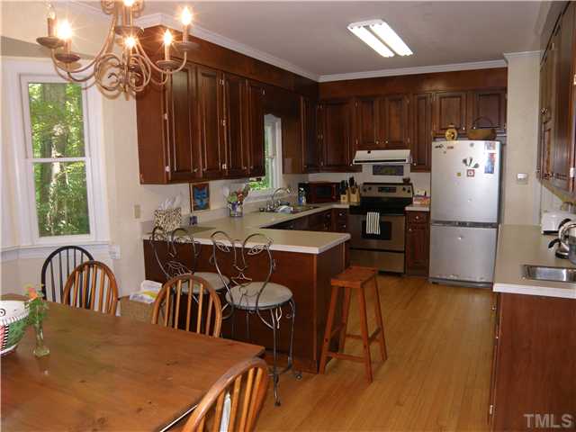 2508 Ashley Court Raleigh, NC 27607 - Photo 4 of 12 Generously sized kitchen with cherry cabinetry and stainless steel appliances. There is a second sink for additional work space. Very lovely views from the breakfast area.