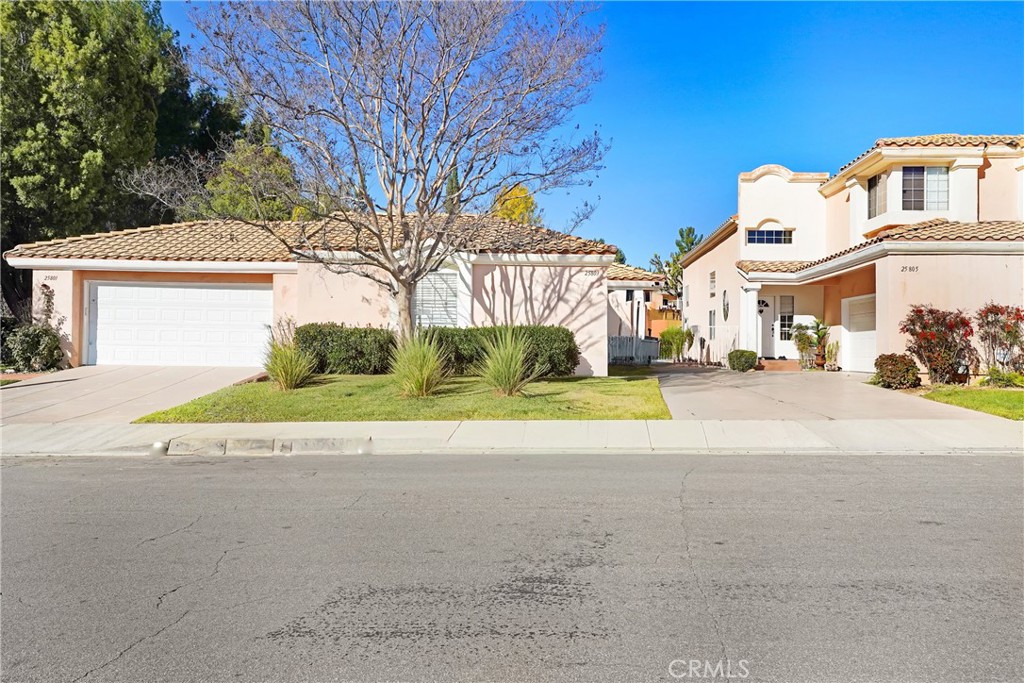 25803 Browning Place Stevenson Ranch, CA 91381 - Photo 2 of 20 a view of a white house with a yard and potted plants