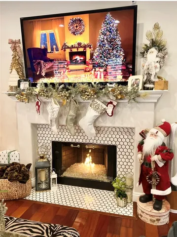 a view of a livingroom with a fireplace a flat screen tv and staircase