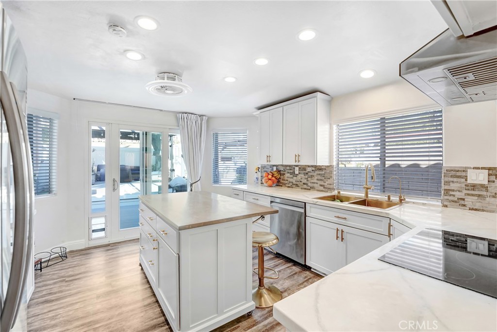 25803 Browning Place Stevenson Ranch, CA 91381 - Photo 6 of 20 a kitchen with counter top space sink stainless steel appliances and windows