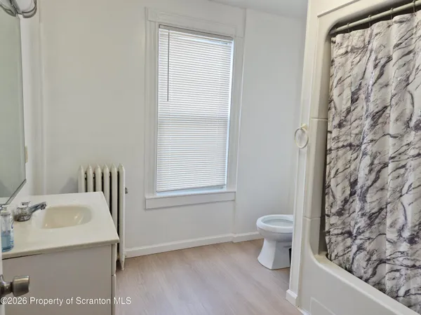 a bathroom with a sink toilet and window