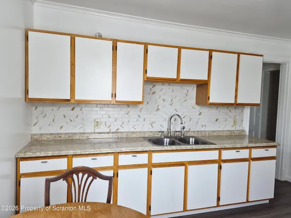 a kitchen with stainless steel appliances granite countertop white cabinets a sink and a large window