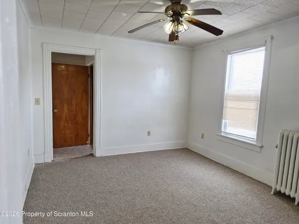 an empty room with windows and fan